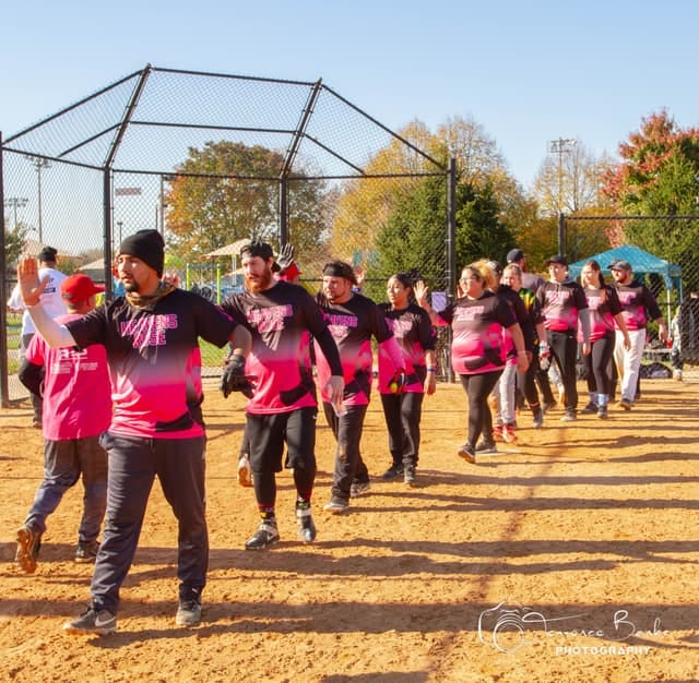 Frederick Social Sports softball players exchanging high-fives